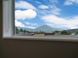 View of a mountain and houses from a window at Motuoapa Holiday Home in Motuoapa