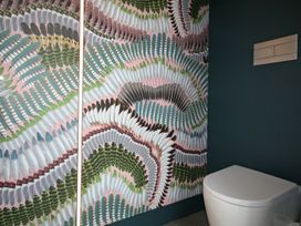 A bathroom with a toilet and decorative wallpaper at New Plymouth Holiday Home in New Plymouth