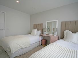 A bedroom with two beds and a mirror at New Plymouth Holiday Home in New Plymouth