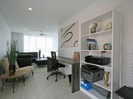 A living room with a sofa and desk at New Plymouth Holiday Home in New Plymouth