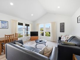 A living room with a sofa, coffee table, and television at Harbour Heights - Akaroa Holiday Home, Akaroa