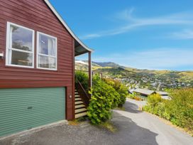 A house exterior with a garage and stairs at Harbour Heights - Akaroa Holiday Home in Akaroa
