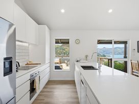 A kitchen with white cabinets and ocean view at Harbour Heights - Akaroa Holiday Home Akaroa