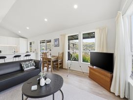 A living room with a sofa, coffee table and television at Harbour Heights - Akaroa Holiday Home, Akaroa