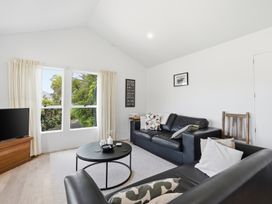 A living room with sofa and television at Harbour Heights - Akaroa Holiday Home in Akaroa