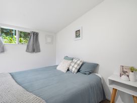 A bedroom with a bed and decorative items at Harbour Heights - Akaroa Holiday Home in Akaroa