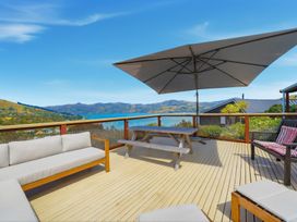 A deck with outdoor seating and a table at Harbour Heights - Akaroa Holiday Home in Akaroa