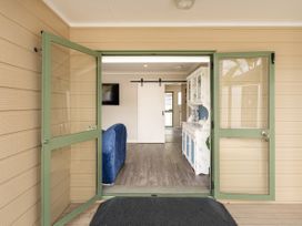 An entryway with a green door and a view into the living area at Petit Paradis - Whitianga Holiday Home Whitianga