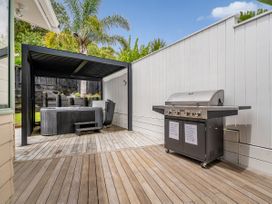 An outdoor space with a grill and a hot tub at Petit Paradis - Whitianga Holiday Home, Whitianga