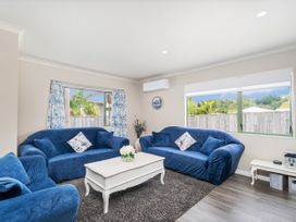 A living room with blue sofas and a coffee table at Petit Paradis - Whitianga Holiday Home Whitianga