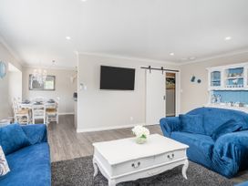 A living room with sofa and coffee table at Petit Paradis - Whitianga Holiday Home