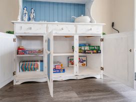A cabinet with board games stored inside at Petit Paradis - Whitianga Holiday Home