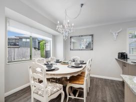 A dining room with a table set for dinner at Petit Paradis - Whitianga Holiday Home