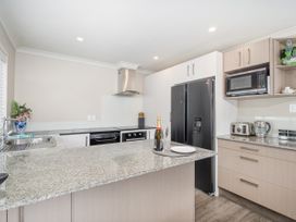 A kitchen with a kitchen island and appliances at Petit Paradis - Whitianga