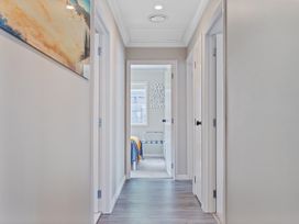 A hallway with doors and a window at Petit Paradis - Whitianga Holiday Home