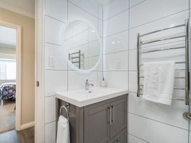 A bathroom with a sink and mirror at Petit Paradis - Whitianga Holiday Home in Whitianga