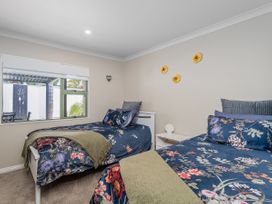 A bedroom with two beds and a window at Petit Paradis - Whitianga Holiday Home Whitianga