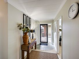 An entryway with table and clock at Napier Holiday Home in Napier