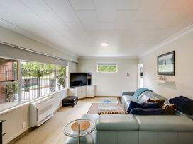 A living room with a sofa and television at Napier Holiday Home in Napier