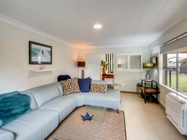 A living room with a couch and coffee table at Napier Holiday Home in Napier