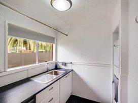 A kitchen with a sink and washing machine at Napier Holiday Home in Napier