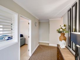 A hallway with a clock and a vase at Napier Holiday Home in Napier