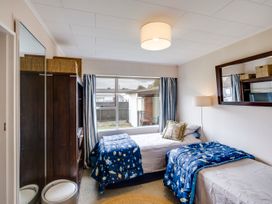 A bedroom with two beds and a window at Napier Holiday Home in Napier