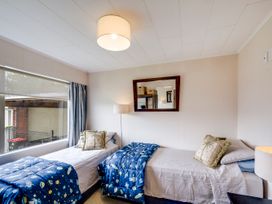 A bedroom with two single beds and a mirror at Napier Holiday Home in Napier