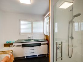 A bathroom featuring a bathtub, shower, and sink at Napier Holiday Home, Napier
