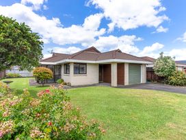 A house with a garage and garden at Orewa Holiday Home in Orewa