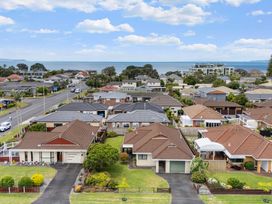 A view of residential houses and the sea at Sunny Oasis - Orewa Beach Holiday Home in Orewa