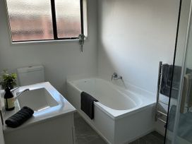 A bathroom with bathtub, sink, and toilet at The Orewa Beach House - 200 Steps to Orewa Beach in Orewa