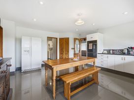 A kitchen with a table and refrigerator at JD'S Place - Akaroa Holiday Home, Akaroa