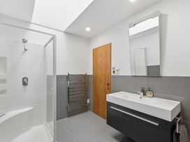 A bathroom with a shower and vanity at JD'S Place - Akaroa Holiday Home Akaroa