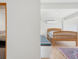 A bedroom with two beds and a bench at JD'S Place - Akaroa Holiday Home in Akaroa