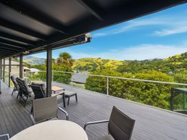 A deck with outdoor seating and a view of hills at JD'S Place - Akaroa Holiday Home, Akaroa
