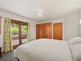 A bedroom with a bed and wardrobe at JD'S Place - Akaroa Holiday Home in Akaroa