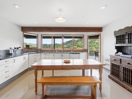 A kitchen with a wooden table and bench at JD'S Place - Akaroa Holiday Home in Akaroa