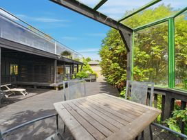 An outdoor area with a wooden table and chairs at JD'S Place - Akaroa Holiday Home in Akaroa