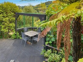 A seating area with a table and chairs in a garden at JD'S Place - Akaroa Holiday Home, Akaroa