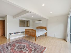 A bedroom with a bed and rug at JD'S Place - Akaroa Holiday Home, Akaroa