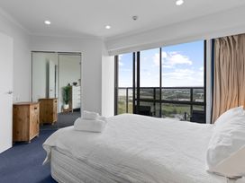 A bedroom with a bed and wooden cabinet at The Old Barn in Auckland
