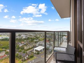A balcony with chairs overlooking the city at Auckland