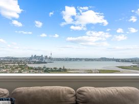 A living room with a view of a city skyline and water at The Old Barn in Auckland