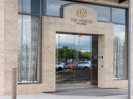 An entrance with glass doors and a sign at The Spencer on Byron in Auckland