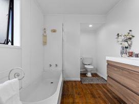 A bathroom with a bathtub and a toilet at Papamoa Beach in Papamoa