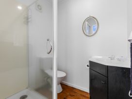 A bathroom with a shower, toilet, and sink at Papamoa Beach, Papamoa