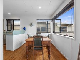 A dining room with a table and chairs at Papamoa Beach in Papamoa