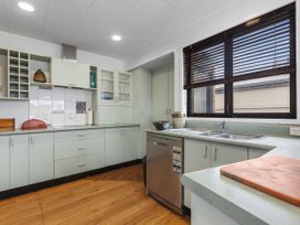 A kitchen with cabinets and a sink at Papamoa Beach in Papamoa