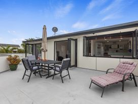 An outdoor terrace with furniture and plants at Papamoa Beach in Papamoa
